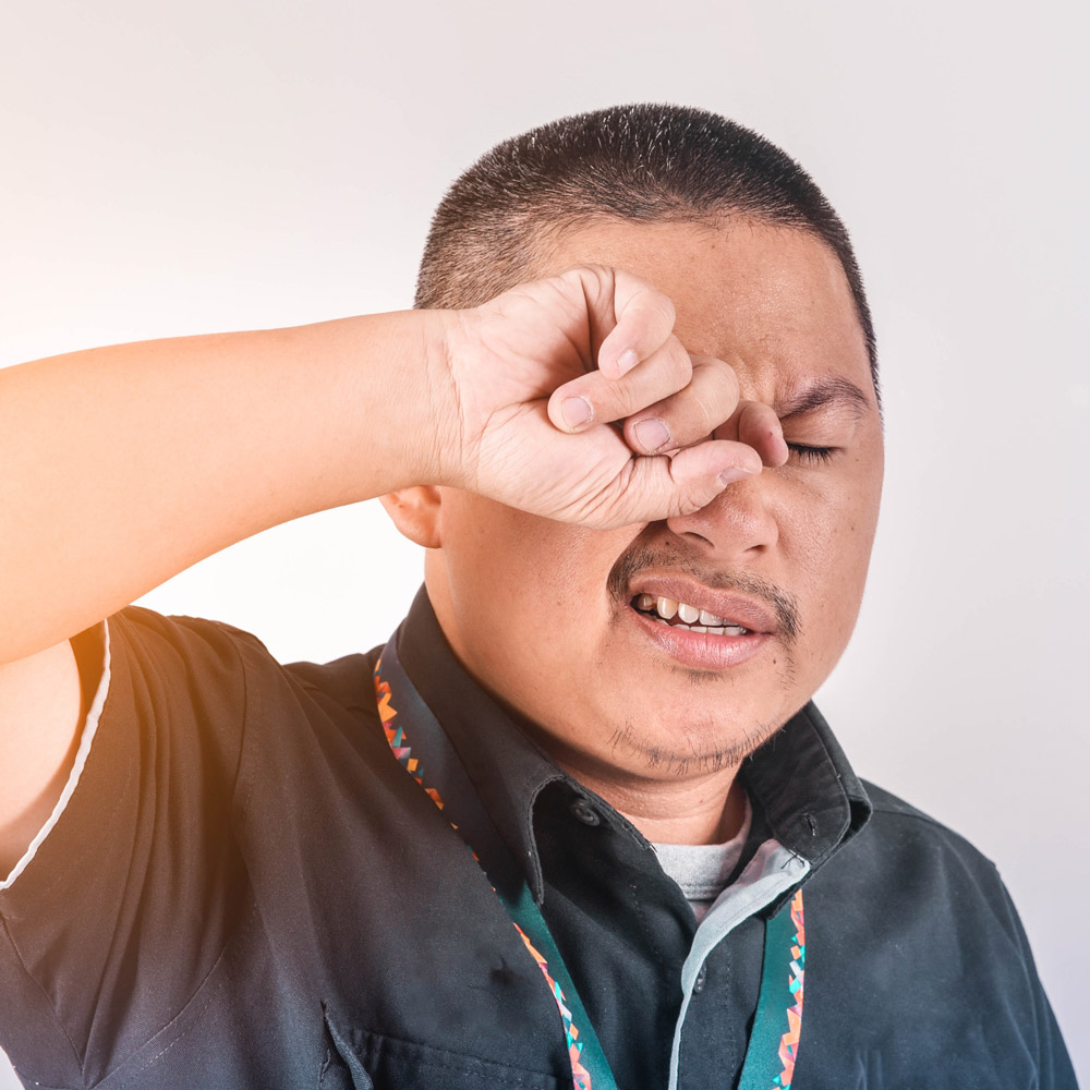 man rubbing eye